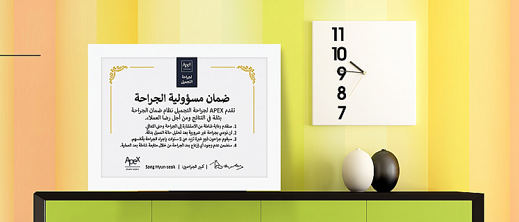 إطار شهادة ضمان مسؤولية الجراحة لعيادة APEX لجراحة التجميل موضوع على رف وبجواره ساعة حائط مربعة