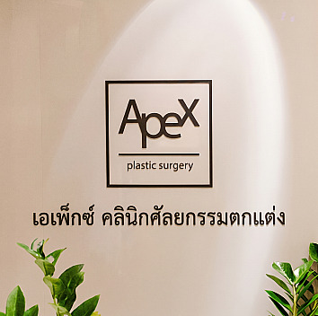 ป้ายโลโก้ APEX Plastic Surgery ภาษาอังกฤษและภาษาเกาหลีบนผนังภายในคลินิกพร้อมไฟส่องสว่าง