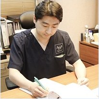 에이펙스성형외과 진료실에서 원장이 수술 플랜 차트를 꼼꼼하게 작성하는 모습