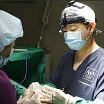 에이펙스성형외과 수술실에서 수술용 헤드라이트와 마스크를 착용한 성형외과 의료진이 수술을 집도하는 모습