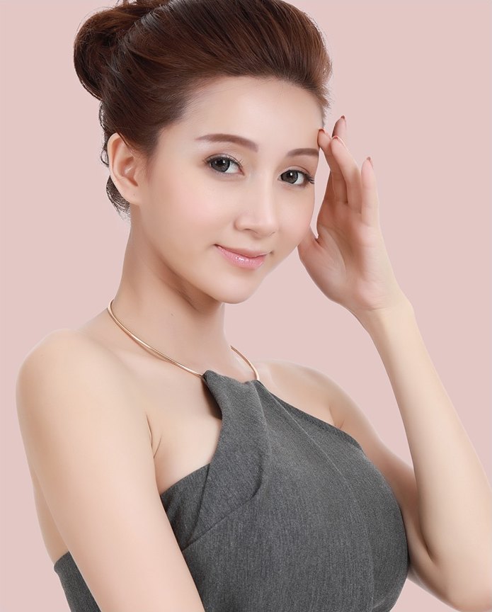 한 손을 이마 관자놀이 쪽에 가볍게 대고 미소 짓고 있는 이마거상술 안내 여성 모델