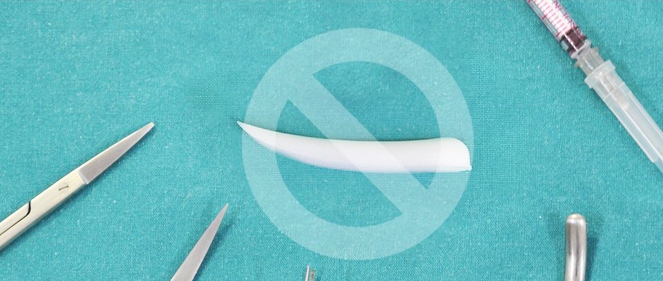 무보형물 코성형 안내를 위해 수술 기구와 실리콘 코 보형물 위에 금지 기호가 표시된 모습