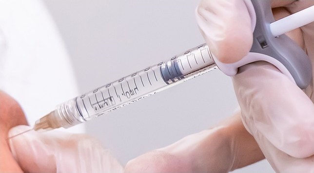 라텍스 장갑을 착용한 의료진이 주사기 형태의 필러 제재를 피부에 정밀하게 주입하는 시술 클로즈업