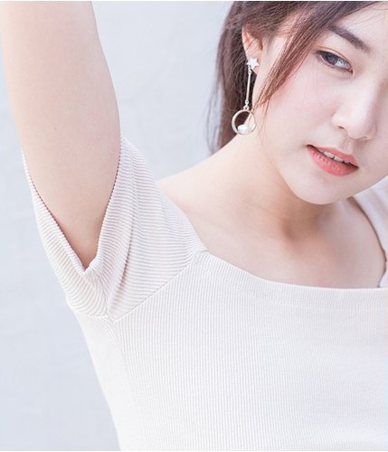 액취증 고민을 나타내듯 밝은 니트 상의를 입고 한쪽 팔을 들어 올린 채 포즈를 취한 여성