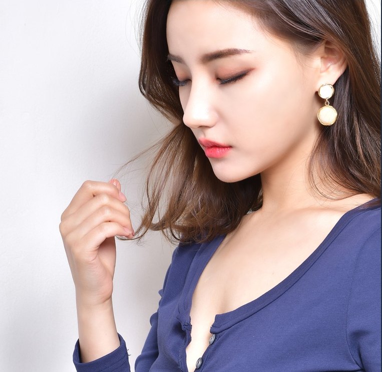 네이비 의상을 입고 눈을 내리깐 채 머리카락을 넘기며 코 라인을 보여주는 짧은코 성형 모델의 옆모습